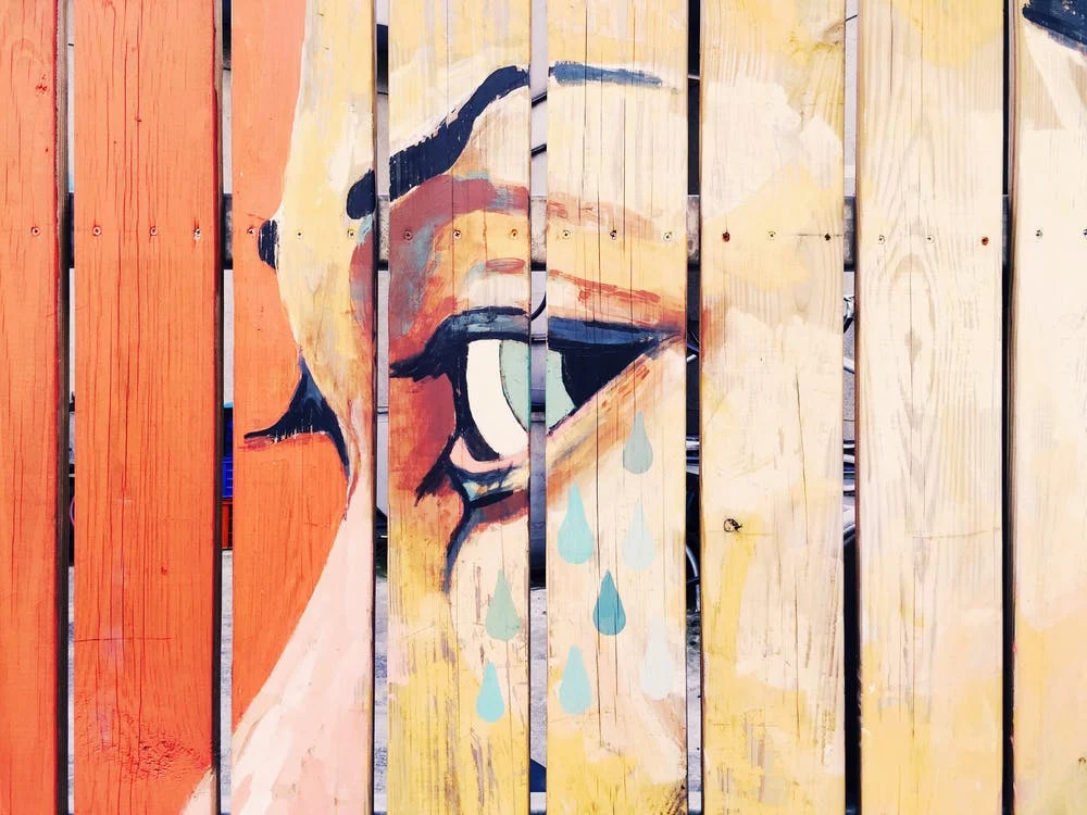 Woman with tears painted on wooden planks