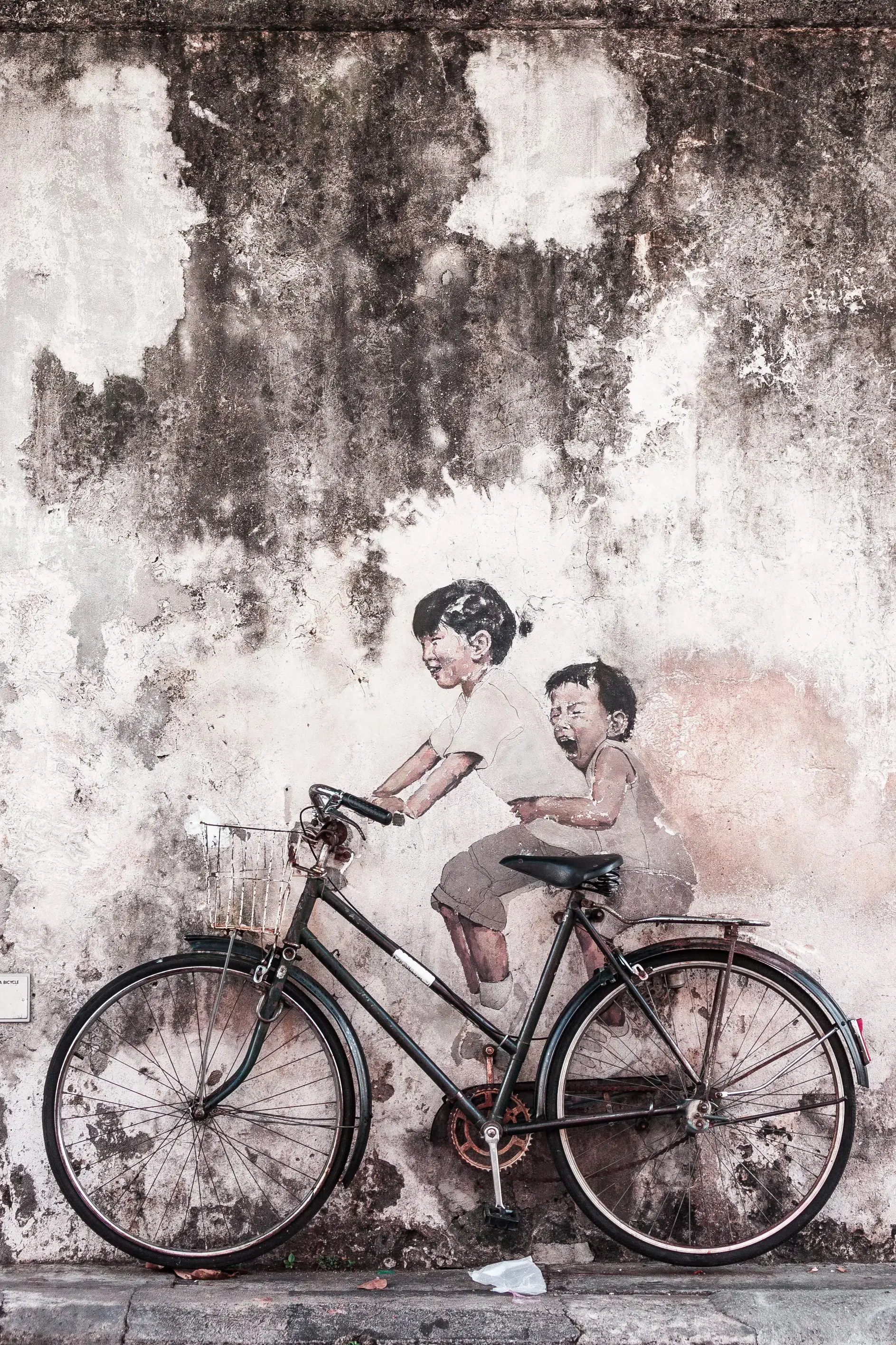 Painting of brother and sister on bicycle